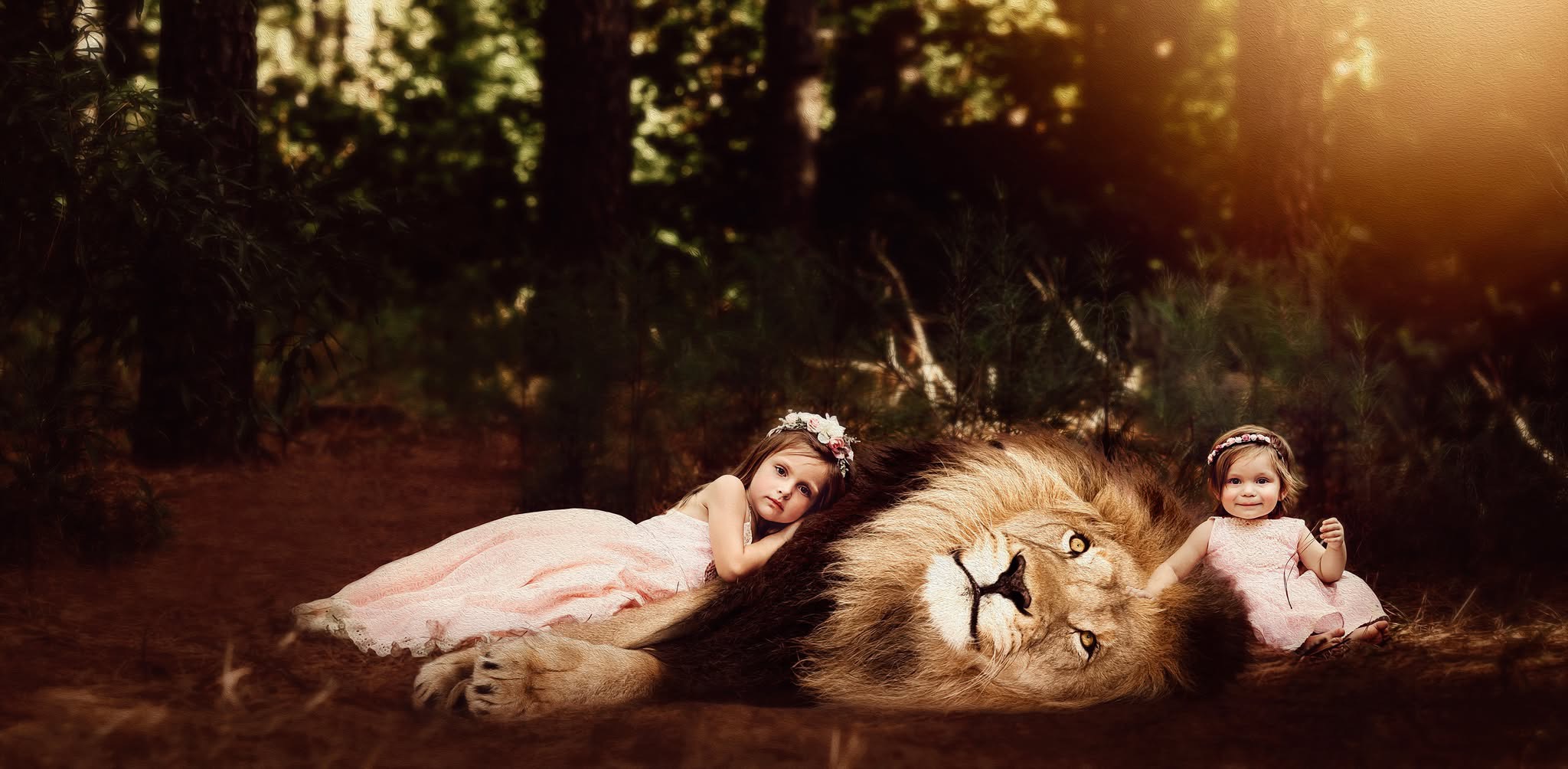 A girl and a small child rest on a lion's body in a forest, with sunlight filtering through trees.
